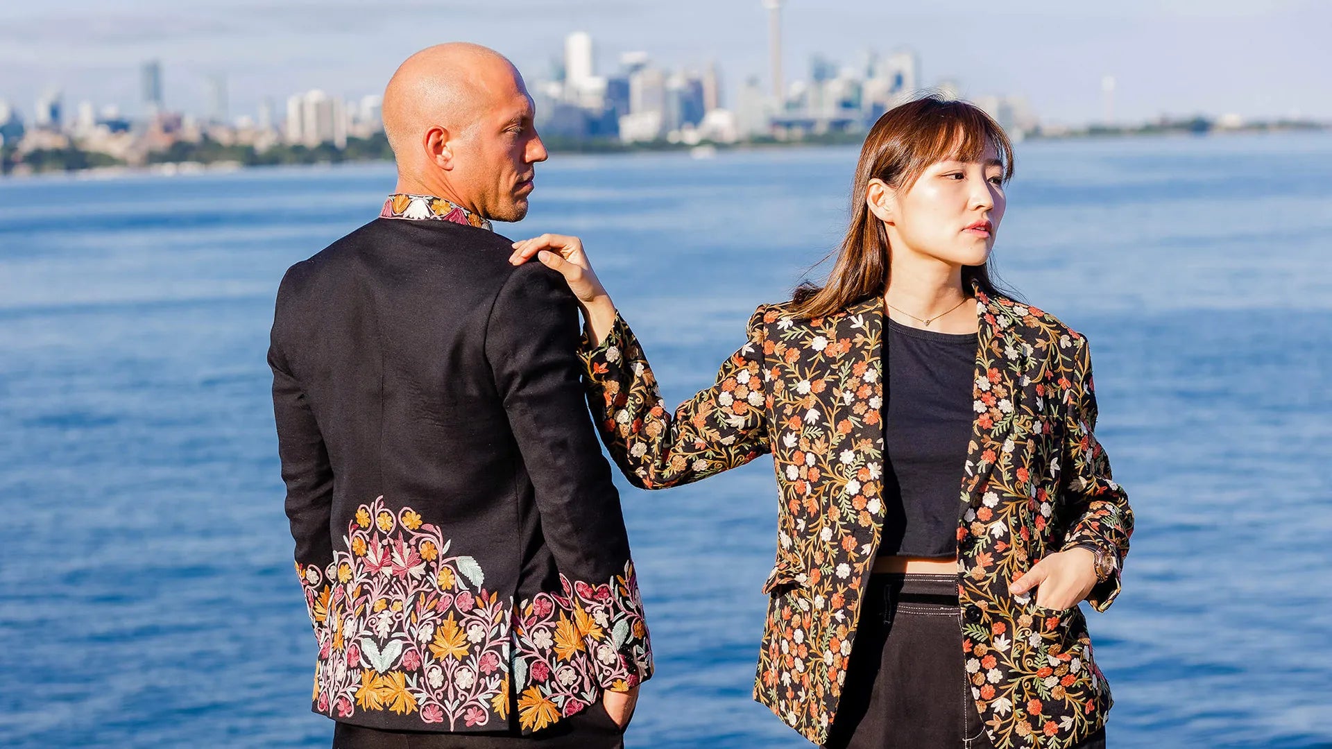 Man and women in formal clothes standing in front of a lake