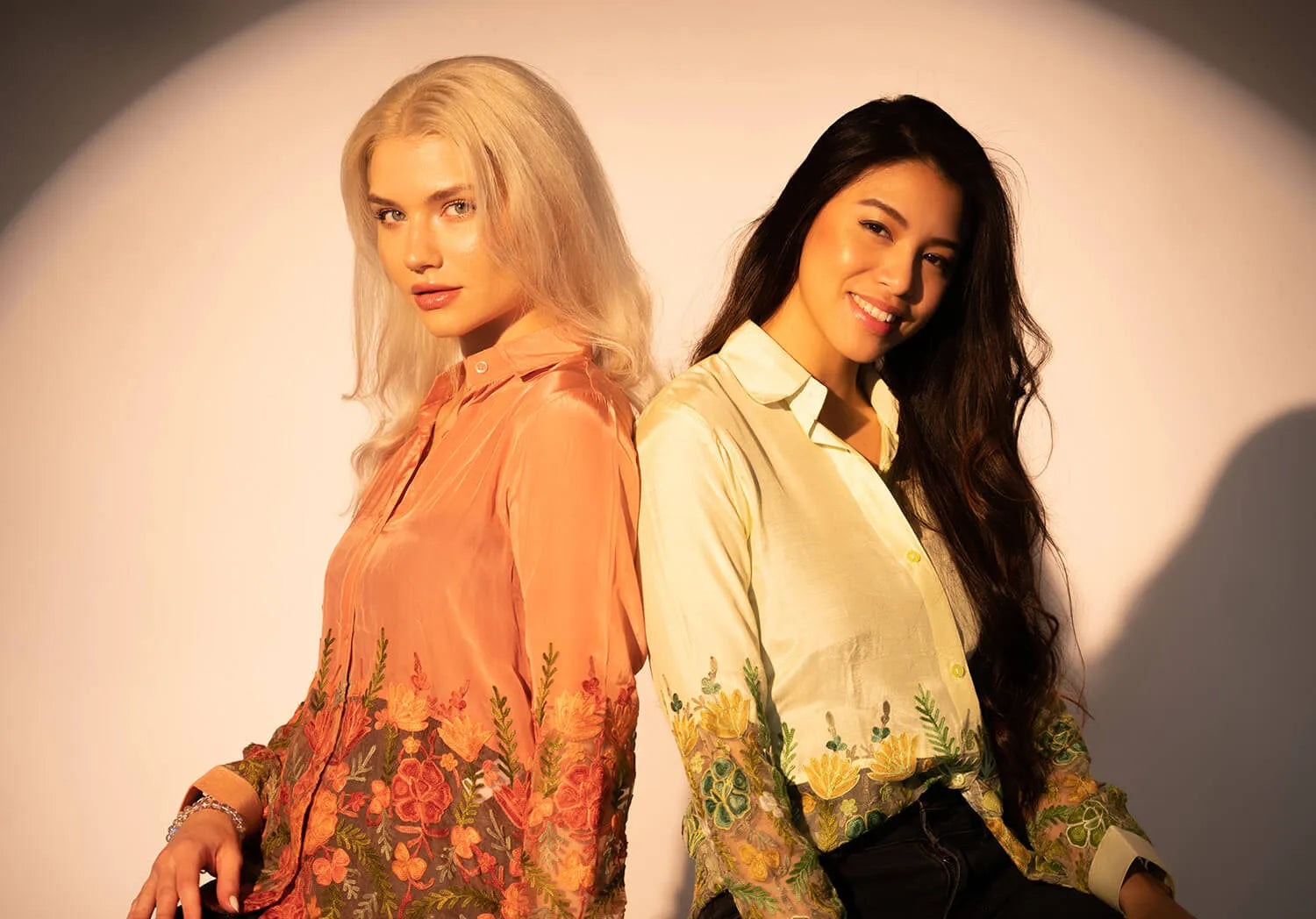 two women sitting back to back